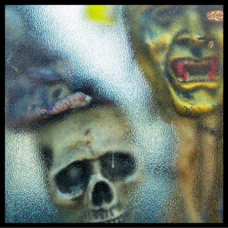 Skull mannequin display reflected in a shop window along the Portuguese Camino route