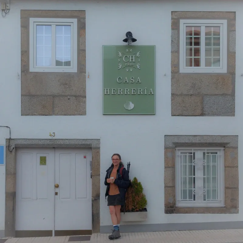 A person stands beside a building with a sign reading "CASA HERRERÍA" and a door numbered 43.
