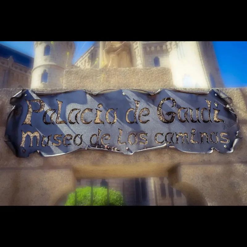 Sign reading "Palacio de Gaudi museo de los caminos," with a castle in the background.
