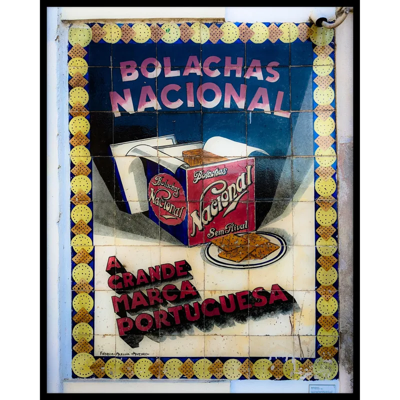 Vintage advertisement tile featuring a red box labeled "Bolachas Nacional" and cookies on a plate, framed by colored borders.